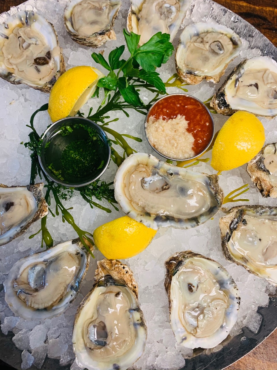 Six Blue Point Long Island Oysters served with cocktail and horseradish sauce and lemon wedges over ice