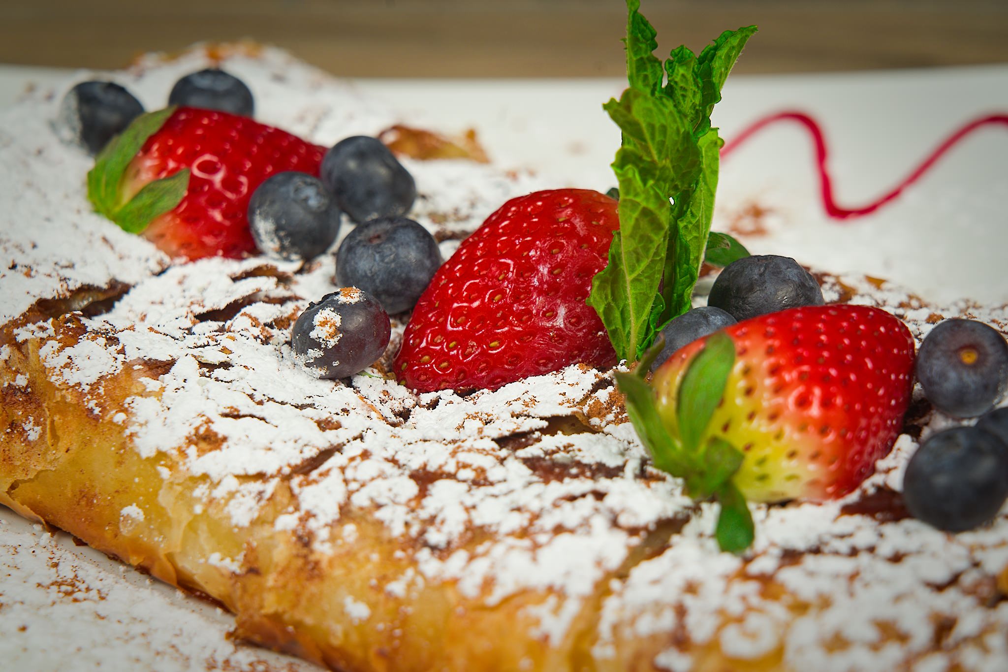 Vanilla Bean Custard Pastry spinkled with powdered sugar and berries