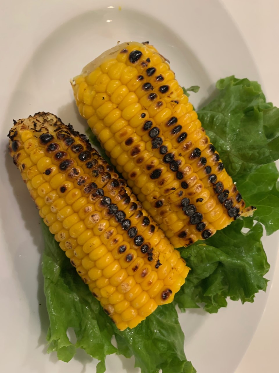 Grilled Corn on the cob garnished with lettuce