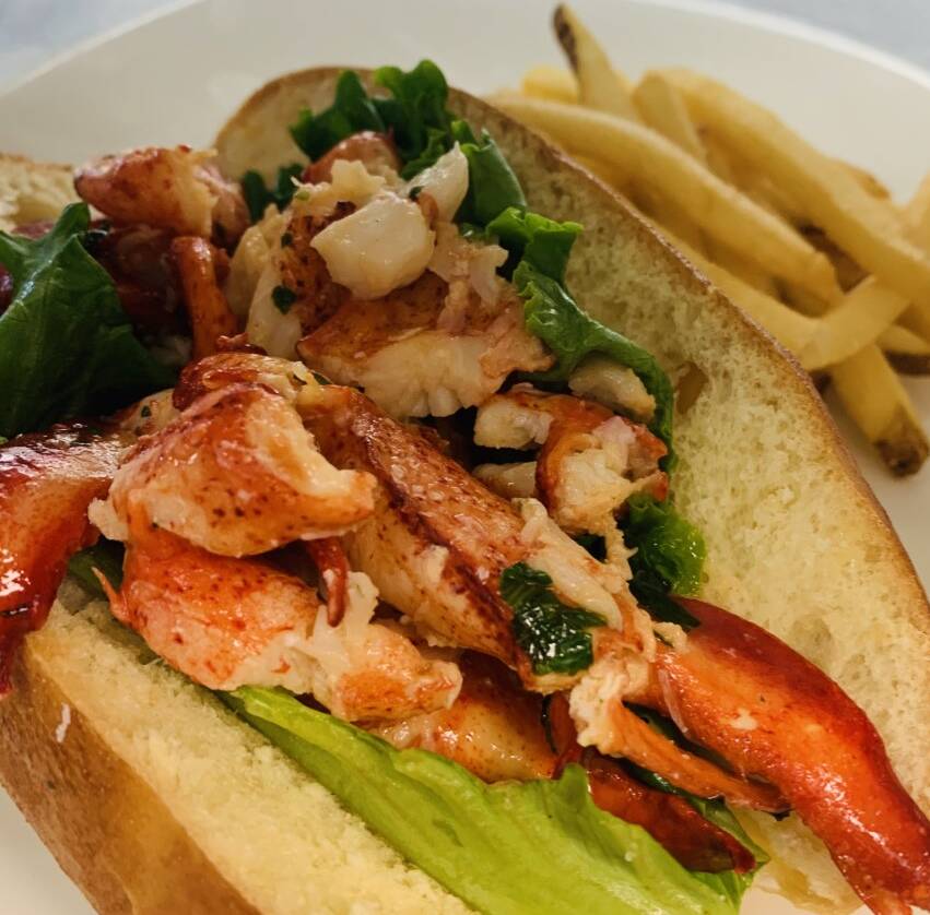 Lobster Roll on a brioche bun with lettuce and served along side hand cut fries.