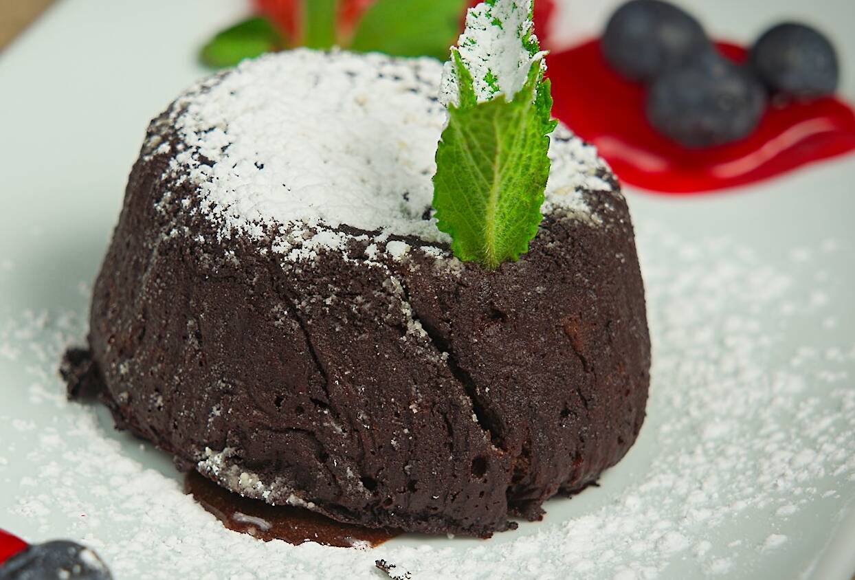 Chocolate lava cake garnished with powdered sugar and berries