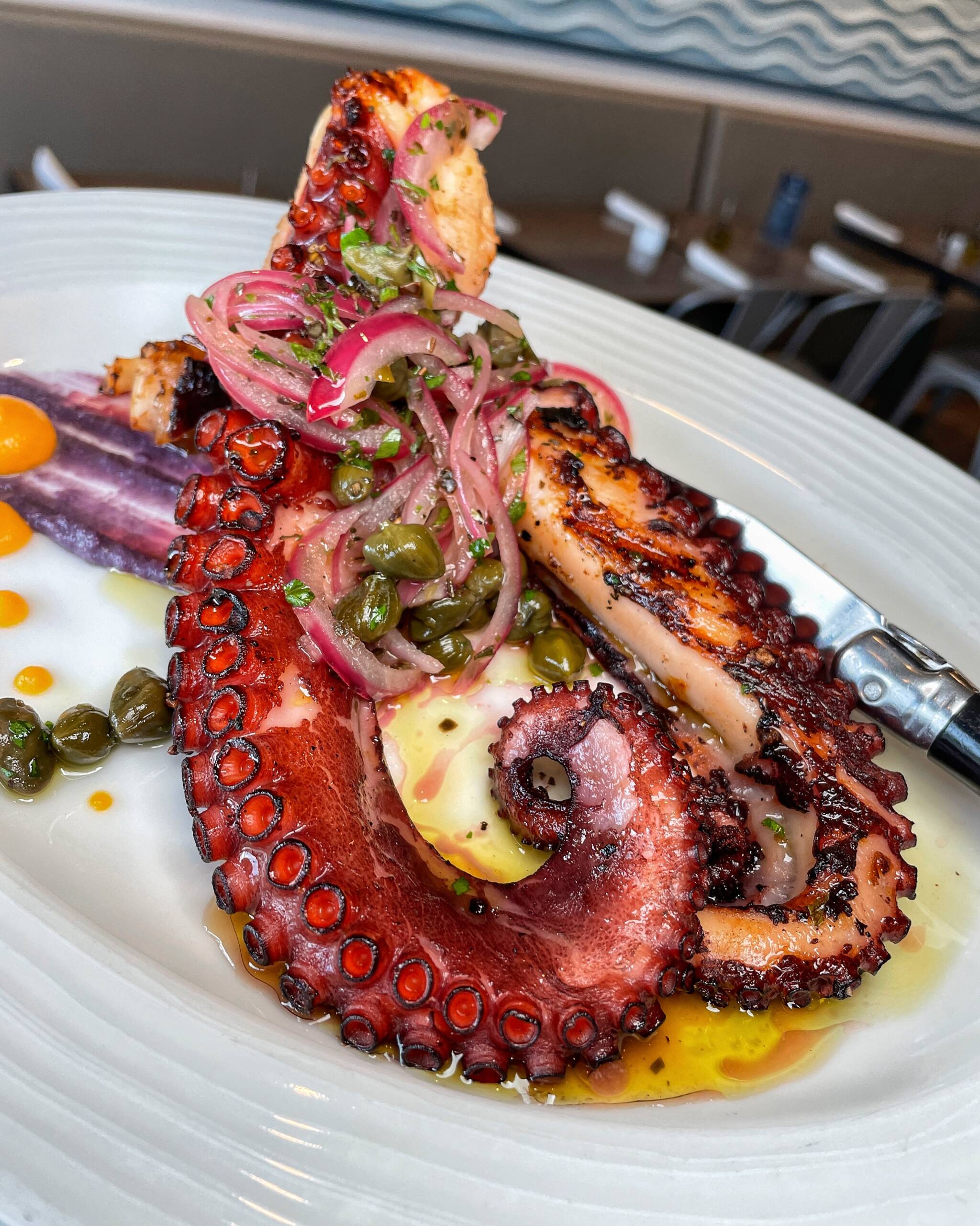 Grilled octopus marinated with red onions, capers, and extra virgin olive oil